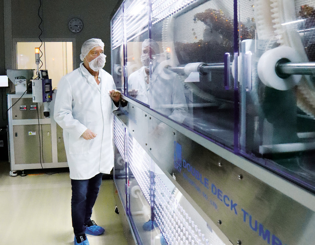 Dr. Peter Hartig in Schutzkleidung bei der Inspektion einer industriellen Algen-Produktionsanlage im Rahmen seiner Forschungstätigkeit.
